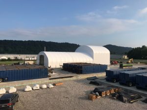 multi-layer fabric structure on a worksite with containers and equipment